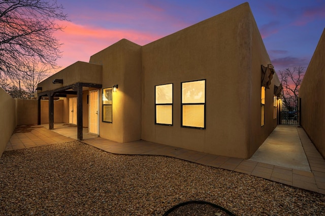 rear view of house featuring stucco siding, a fenced backyard, and a patio