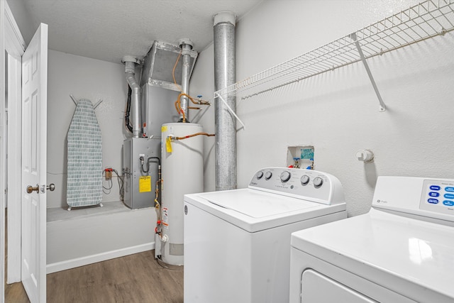 laundry area featuring washing machine and dryer, laundry area, wood finished floors, and gas water heater