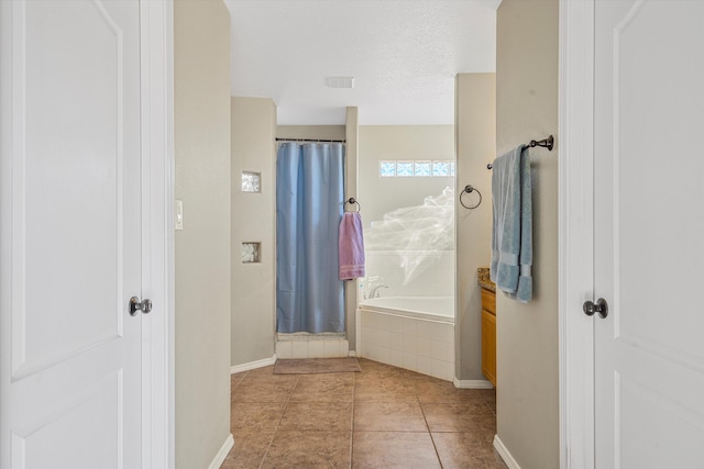 bathroom featuring tile patterned floors, vanity, separate shower and tub, and a textured ceiling