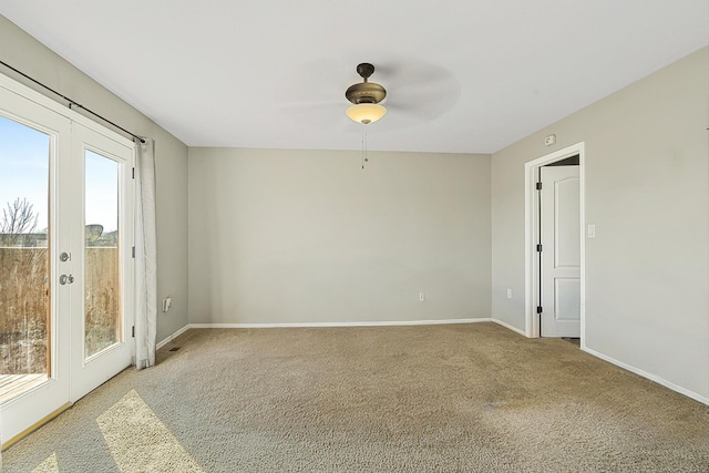 unfurnished room featuring french doors, ceiling fan, and light carpet