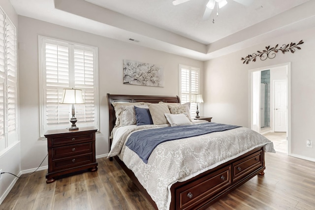 bedroom featuring dark hardwood / wood-style floors and a tray ceiling