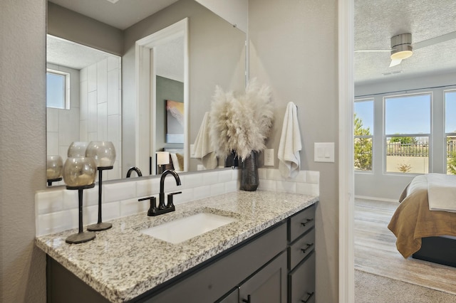 bathroom featuring tasteful backsplash, vanity, and a textured ceiling