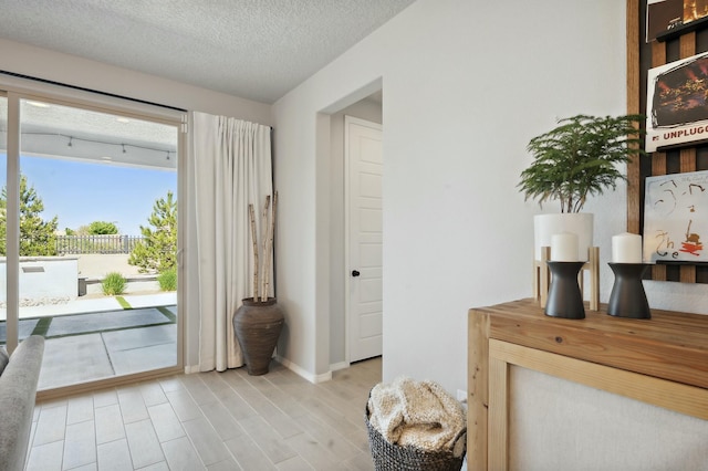 entryway featuring a textured ceiling and light wood-type flooring