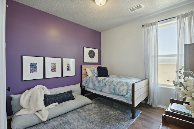 bedroom with hardwood / wood-style floors and a textured ceiling