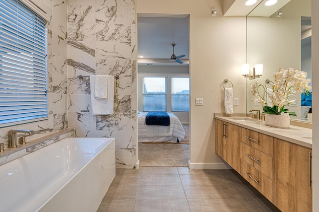 bathroom with tile patterned floors, tile walls, vanity, a bathtub, and ceiling fan