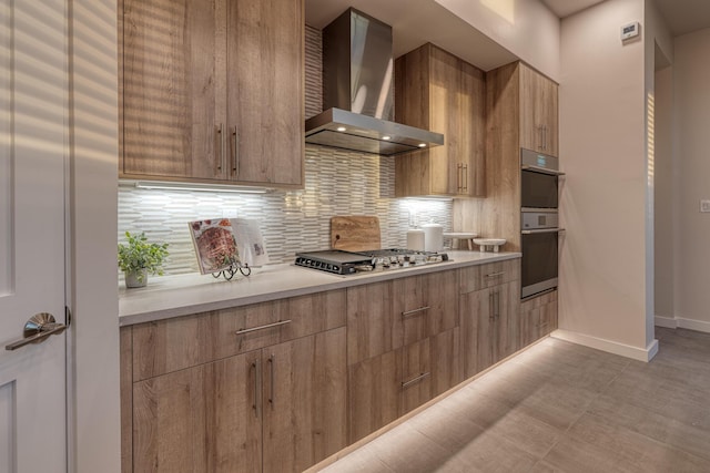 kitchen featuring wall chimney range hood, decorative backsplash, and appliances with stainless steel finishes