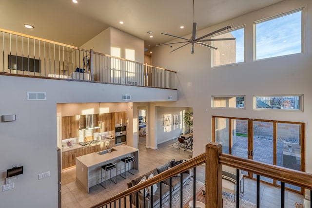 interior space featuring a towering ceiling, sink, and ceiling fan