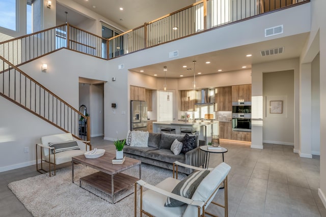 tiled living room featuring a high ceiling and sink