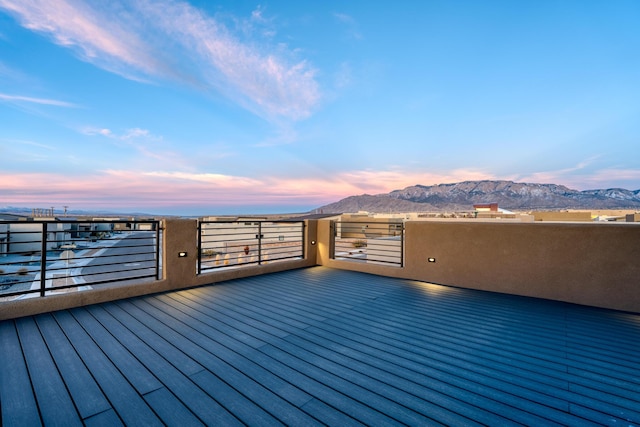 deck at dusk featuring a mountain view