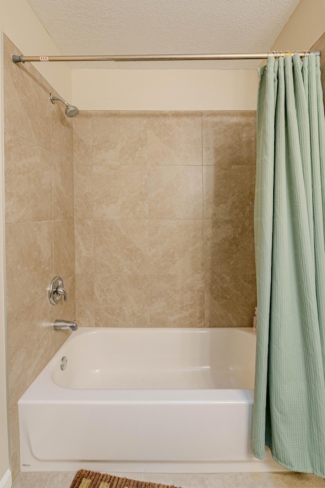 full bathroom featuring shower / bath combo, a textured ceiling, and tile patterned floors