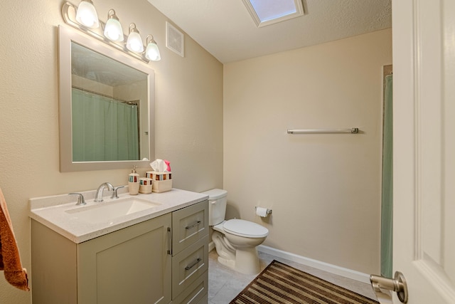 bathroom featuring toilet, vanity, visible vents, baseboards, and tile patterned floors