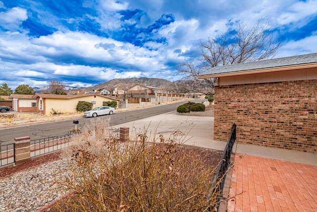 view of street with sidewalks, a residential view, and a mountain view