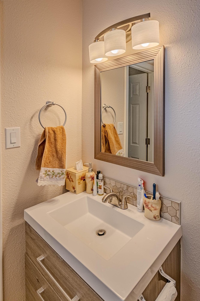 bathroom featuring a textured wall and vanity