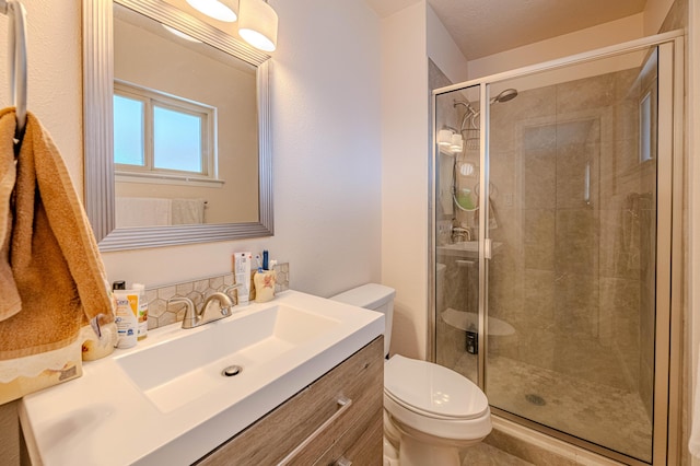 full bathroom with a stall shower, vanity, and toilet