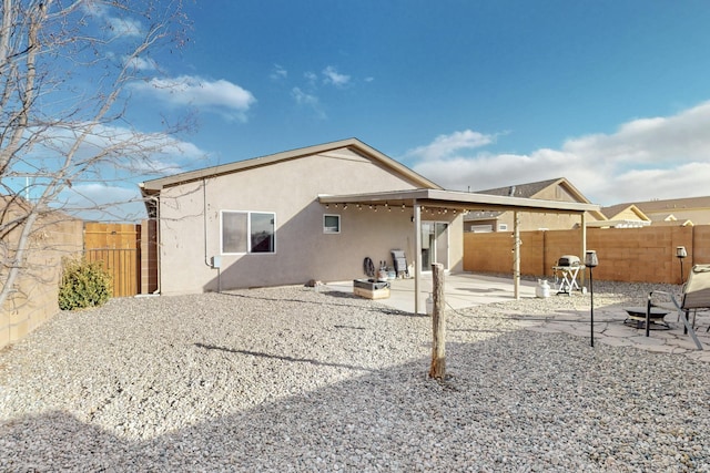 back of house with an outdoor fire pit and a patio area