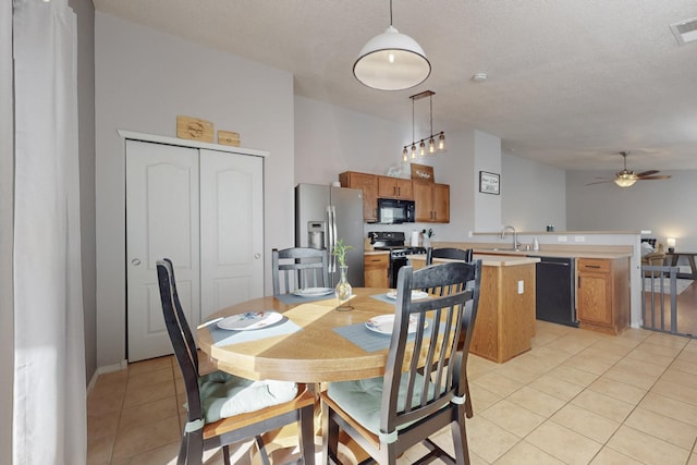 dining room featuring sink, a textured ceiling, ceiling fan, and light tile patterned flooring