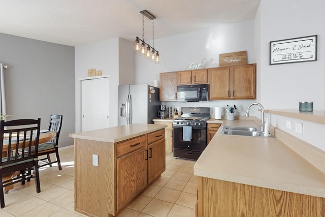 kitchen with decorative light fixtures, sink, a center island, light tile patterned floors, and black appliances