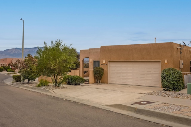 pueblo-style home featuring a mountain view and a garage