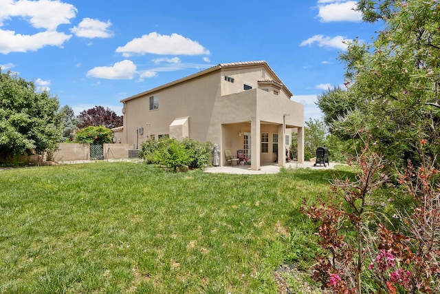 rear view of house featuring cooling unit, a lawn, a balcony, and a patio area