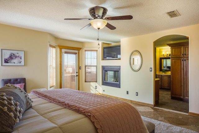 bedroom with ceiling fan and a textured ceiling