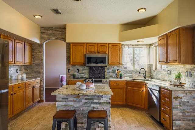 11001 Alta Dr NW, Albuquerque, NM 87114 - kitchen with backsplash, a sink, appliances with stainless steel finishes, and light stone counters