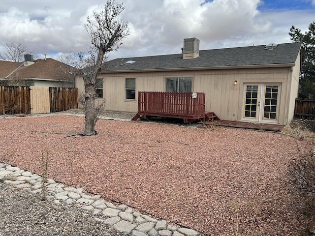 rear view of house featuring french doors, roof with shingles, fence, and a wooden deck