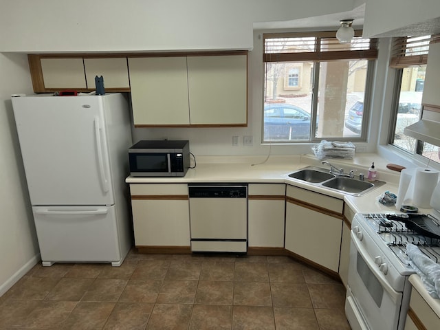 kitchen with light countertops, white appliances, tile patterned flooring, and a sink