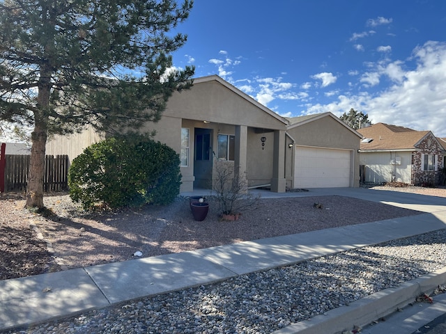 ranch-style home featuring driveway, a garage, fence, and stucco siding