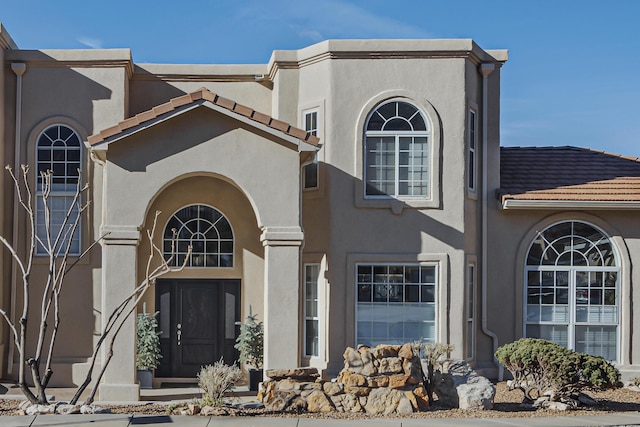 view of front of home with a tile roof and stucco siding