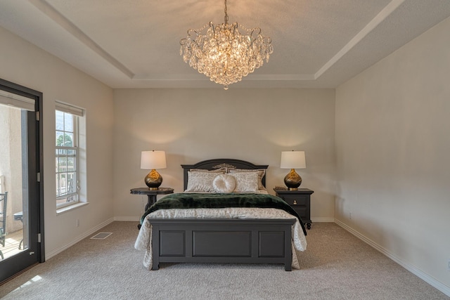 bedroom with a tray ceiling, visible vents, and baseboards