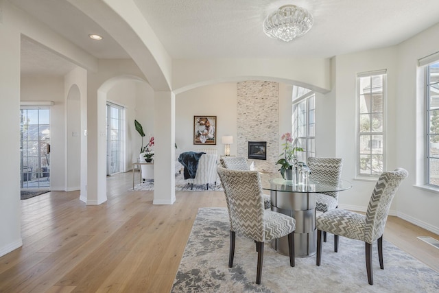 dining area with visible vents, a fireplace, plenty of natural light, and light wood-style flooring