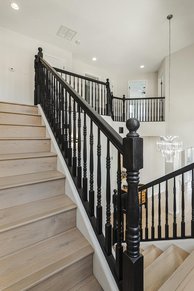 stairs featuring a chandelier and recessed lighting