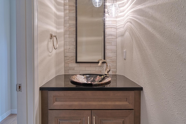 bathroom featuring a textured wall and vanity