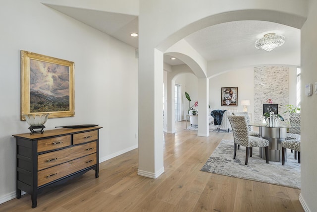 dining area with arched walkways, recessed lighting, baseboards, and wood finished floors