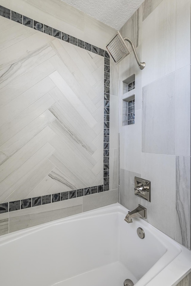 full bathroom featuring a textured ceiling and bathing tub / shower combination