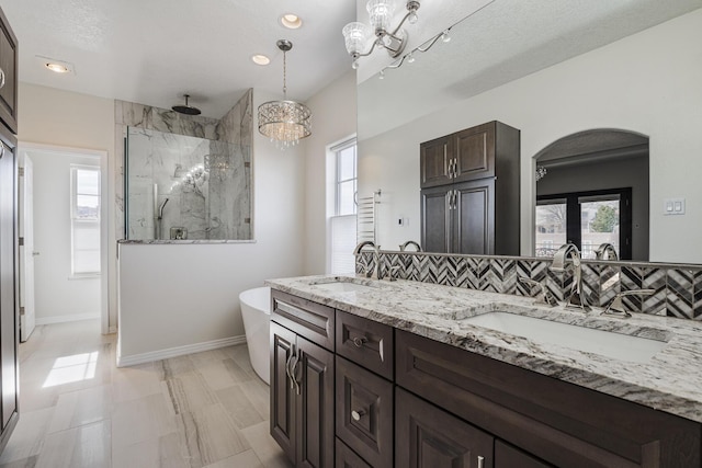 full bathroom featuring plenty of natural light, a marble finish shower, and a sink