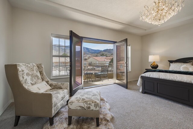 bedroom with baseboards, an inviting chandelier, carpet, access to outside, and a mountain view