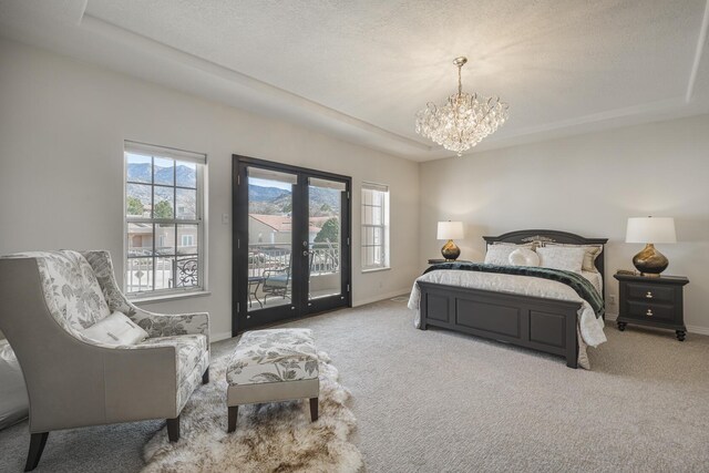 bedroom featuring light carpet, access to outside, multiple windows, and a tray ceiling