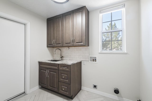 washroom with hookup for a washing machine, a sink, baseboards, cabinet space, and electric dryer hookup