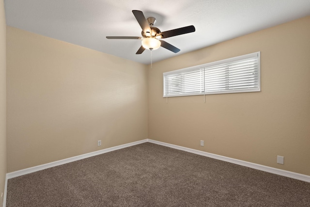 carpeted empty room with ceiling fan and baseboards