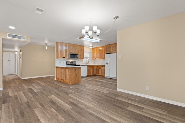 kitchen with stainless steel appliances, visible vents, light countertops, a center island, and decorative light fixtures