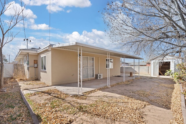 rear view of property with fence and stucco siding