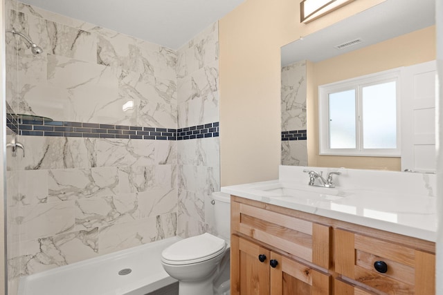 full bath featuring toilet, vanity, a shower stall, and visible vents