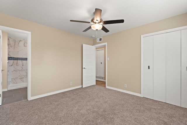 unfurnished bedroom with carpet, a closet, connected bathroom, and baseboards