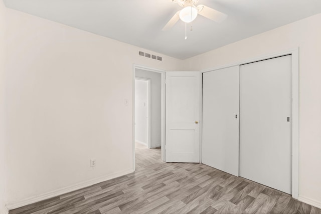 unfurnished bedroom featuring a closet, ceiling fan, and light wood-type flooring