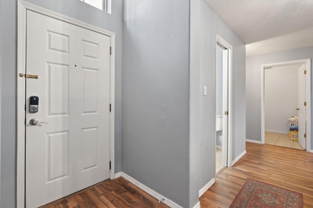 foyer entrance featuring dark wood-type flooring and a textured ceiling