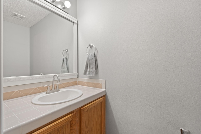 bathroom with vanity and a textured ceiling