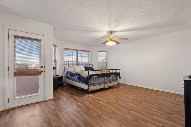 bedroom with dark hardwood / wood-style floors, a textured ceiling, and ceiling fan