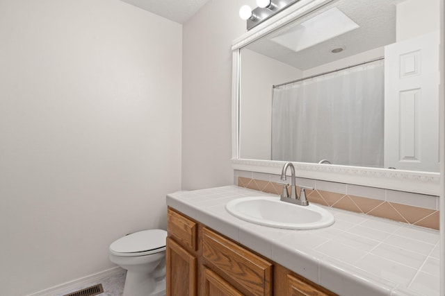 bathroom featuring walk in shower, vanity, and toilet