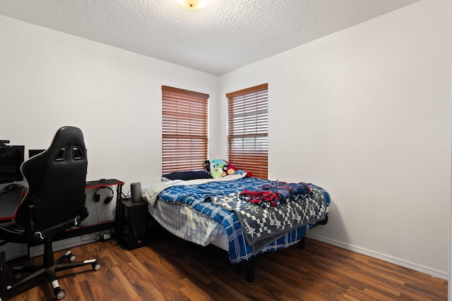 bedroom featuring dark wood-type flooring and a textured ceiling